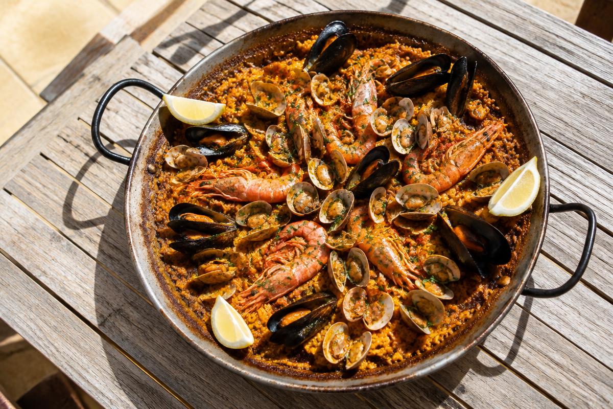 Seafood paella with prawns, mussels and clams in a wide pan